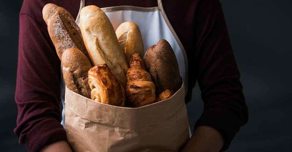 Dame som holder bake-off brød i en pose.